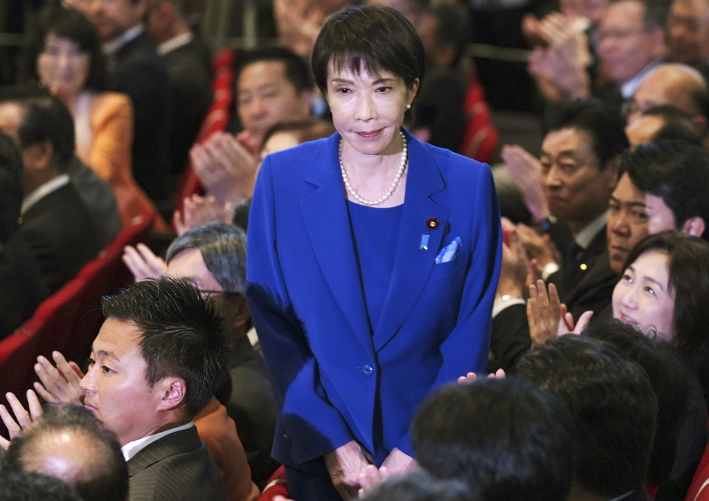 Former Economic Security Minister Sanae Takaichi, center, stands as Takaichi was chosen to a new leader of Japan’s ruling Liberal Democratic Party during the party's leadership election in Tokyo, Japan, Saturday, Oct. 4, 2025. (Yohei Fukai/Kyodo News via AP)