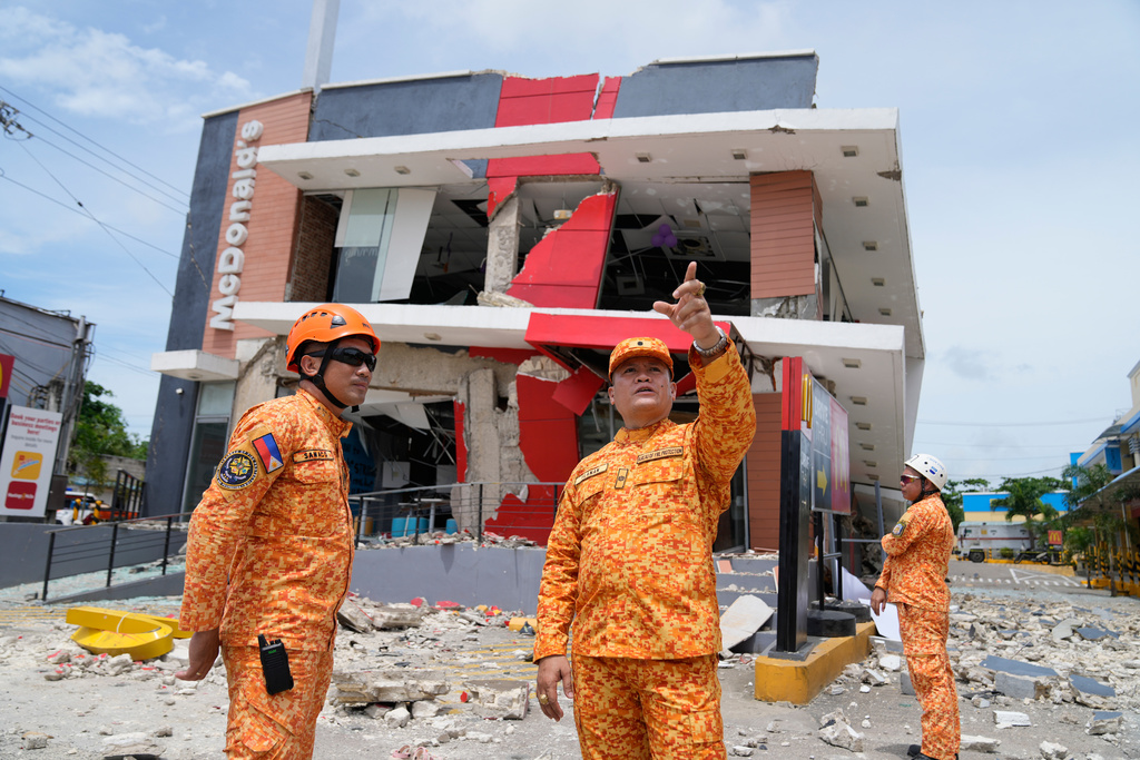 Firemen inspect outside a damaged restaurant on Thursday, Oct. 2, 2025 after Tuesday's strong earthquake in Bogo city, Cebu Province, Central Philippines. (AP Photo/Aaron Favila)