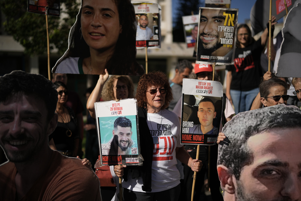 Relatives and supporters of Israeli hostages held by Hamas in the Gaza Strip hold posters with portraits of their loved ones during a protest demanding their immediate release and calling for a ceasefire, in Jerusalem, Tuesday, Oct. 7, 2025, on the second anniversary of Hamas' cross-border attack on Israel on Oct. 7, 2023, which sparked the ongoing war in Gaza. (AP Photo/Leo Correa)