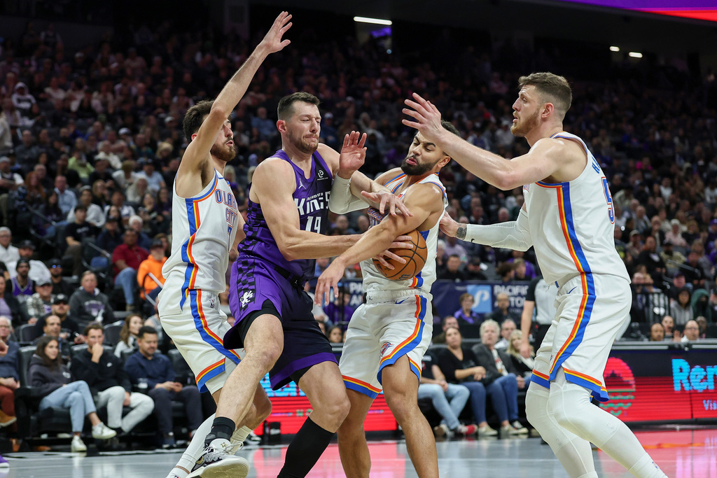 Sacramento Kings forward Drew Eubanks, second to left, and Oklahoma City Thunder guard Ajay Mitchell, second to right, battle for the rebound and during the first half of an NBA Cup basketball game, Friday, Nov. 7, 2025, in Sacramento, Calif. (AP Photo/Sara Nevis)