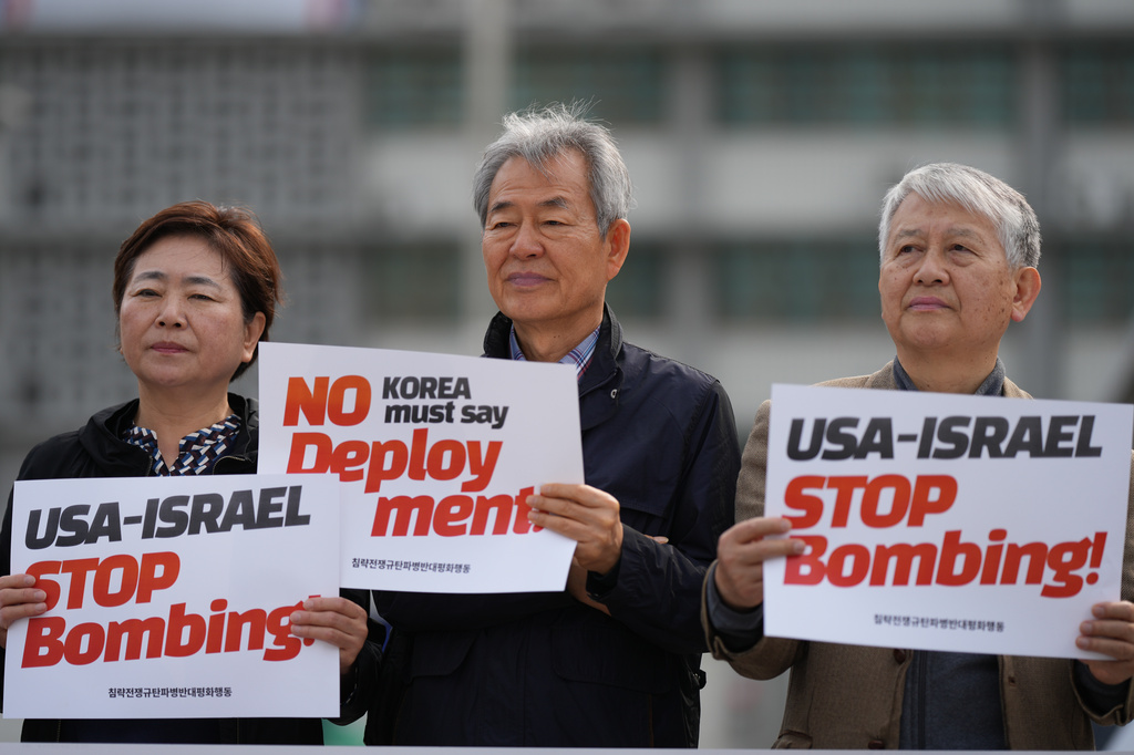 Members of civic groups hold signs against the U.S. and Israel attacks on Iran near the U.S. Embassy in Seoul, South Korea, Wednesday, April 1, 2026. (AP Photo/Lee Jin-man)