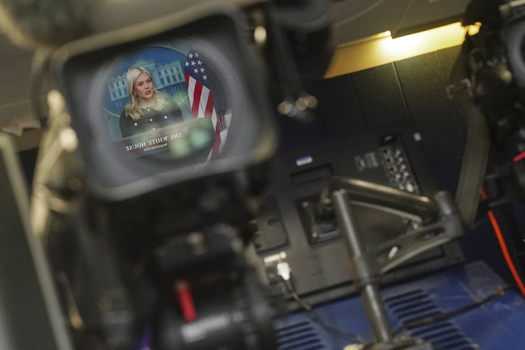 White House press secretary Karoline Leavitt is reflected in a video camera lens as she speaks during a briefing in the James Brady Press Briefing Room at the White House, Wednesday, Feb. 18, 2026, in Washington. (AP Photo/Nathan Howard)