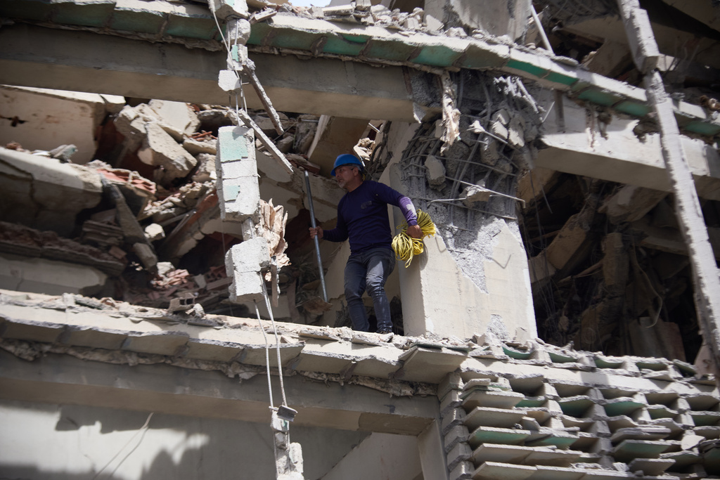 A rescue worker walks on a damaged building a day after an earthquake and several aftershocks struck in Catia La Mar, Venezuela, Thursday, June 25, 2026. (AP Photo/Jonathan Lanza)