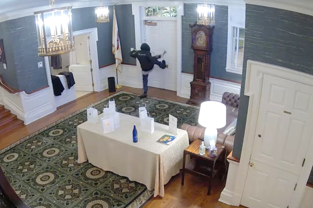This image made from a surveillance video provided by the Dauphin County District Attorney's Office shows Cody Balmer holding a Molotov cocktail and striking at a door leading to where Gov. Josh Shapiro, his family and guests slept in the governor's mansion on April 13, 2025, in Harrisburg, Pa. (Dauphin County District Attorney's Office via AP)