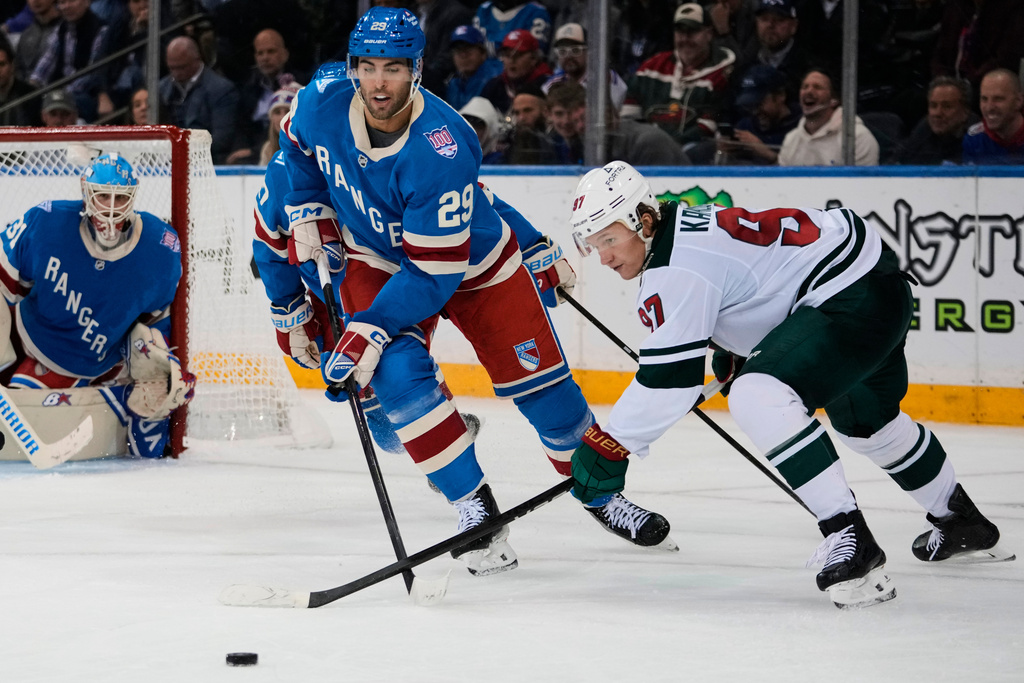 Minnesota Wild's Kirill Kaprizov (97) fights for control of the puck with New York Rangers' Matthew Robertson (29) during the second period of an NHL hockey game Monday, Oct. 20, 2025, at Madison Square Garden in New York. (AP Photo/Frank Franklin II)