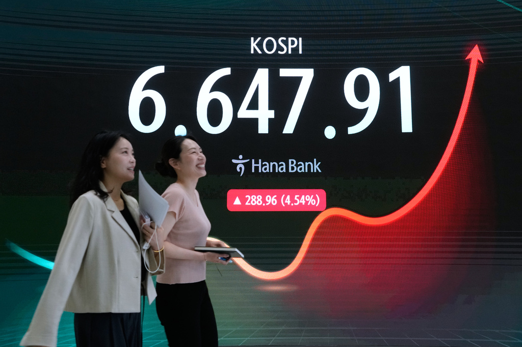 Currency traders pass by a screen showing the Korea Composite Stock Price Index (KOSPI) at the foreign exchange dealing room of the Hana Bank headquarters in Seoul, South Korea, Wednesday, Aug. 5, 2026. (AP Photo/Ahn Young-joon)