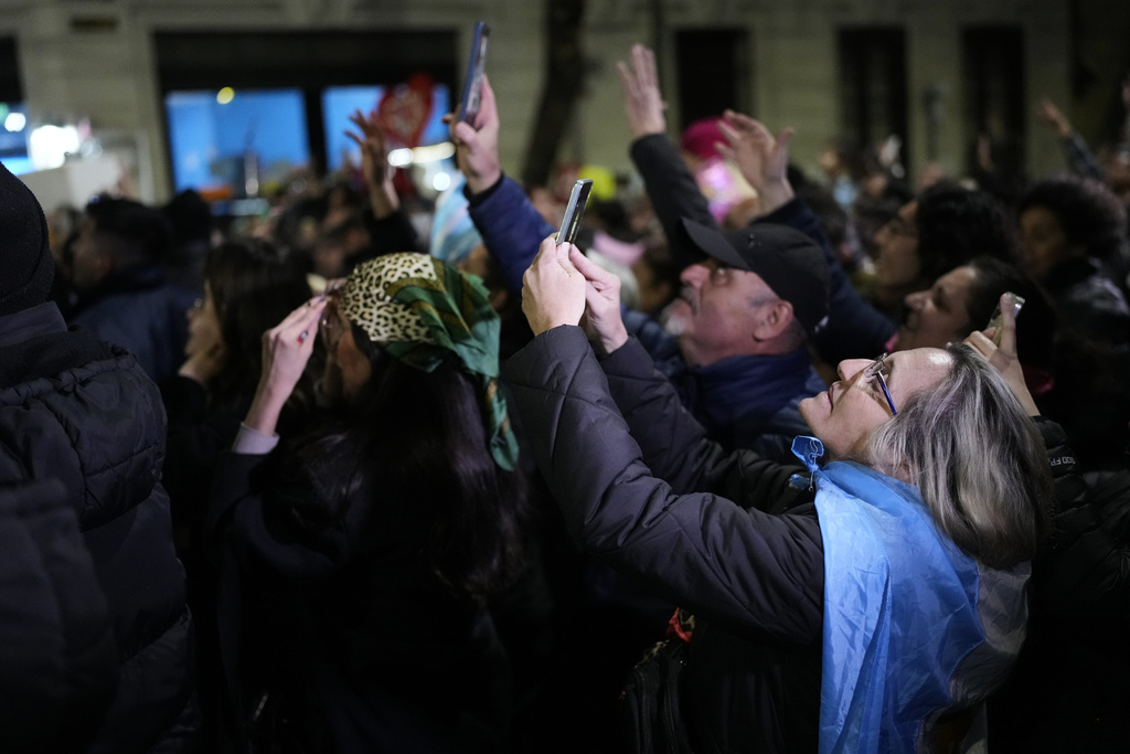 Supporters of former President Cristina Fernandez take pictures of her at the balcony of her home where she is serving a six-year house arrest sentence for corruption, after legislative provincial election polls closed, in Buenos Aires, Argentina, Sunday, Sept. 7, 2025. (AP Photo/Natacha Pisarenko)