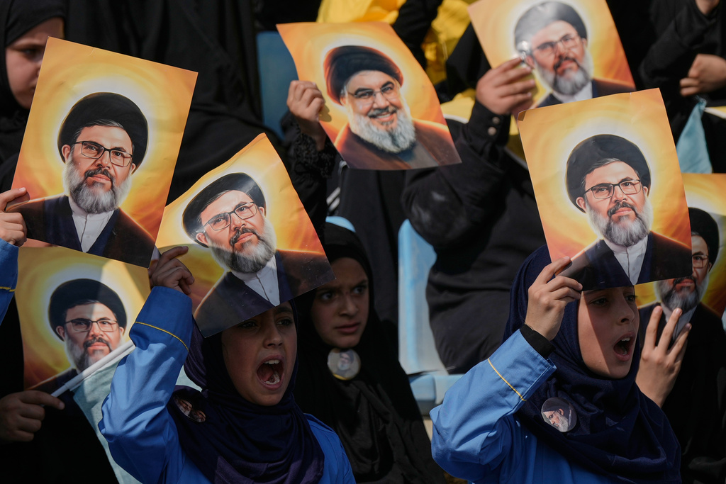 Hezbollah's al-Mahdi Scouts hold pictures of Hezbollah's former leader Hassan Nasrallah and his cousin and successor Hashem Safieddine, to marking the first anniversary of their assassination, who were killed in Israeli airstrikes, at Sports City Stadium in Beirut, Lebanon, Sunday, Oct. 12, 2025. (AP Photo/Bilal Hussein)