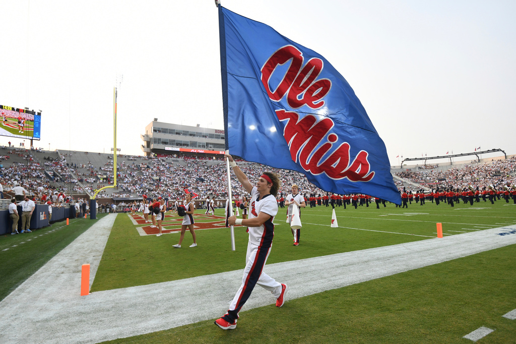FILE - A cheerleader runs with a flag during an NCAA college football game between Mississippi and Austin Peay at Vaught-Hemingway Stadium in Oxford, Miss., Sept. 11, 2021. (AP Photo/Bruce Newman, File)