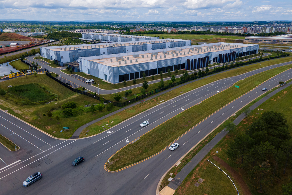 FILE - Cars drive past data centers that house computer servers and hardware required to support modern internet use, such as artificial intelligence, in Ashburn, Virginia, July 16, 2023. (AP Photo/Ted Shaffrey, File)