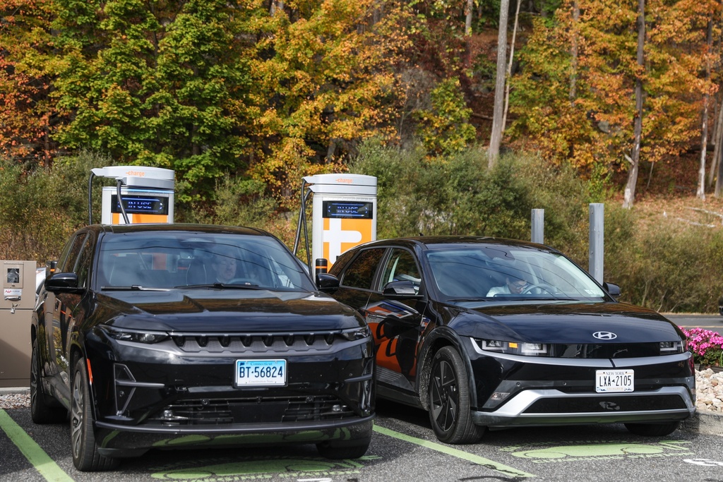 People sit in their electric vehicles while using a Level 3 EV charger Saturday, Oct. 11, 2025, in Ridgefield, Conn. (AP Photo/Heather Khalifa)