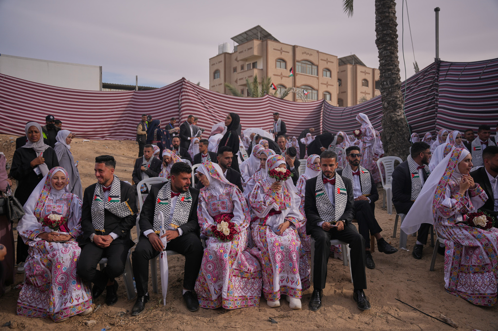 Palestinian couples participate in a mass wedding ceremony in Deir al-Balah, central Gaza Strip, Friday, April 24, 2026. (AP Photo/Abdel Kareem Hana)