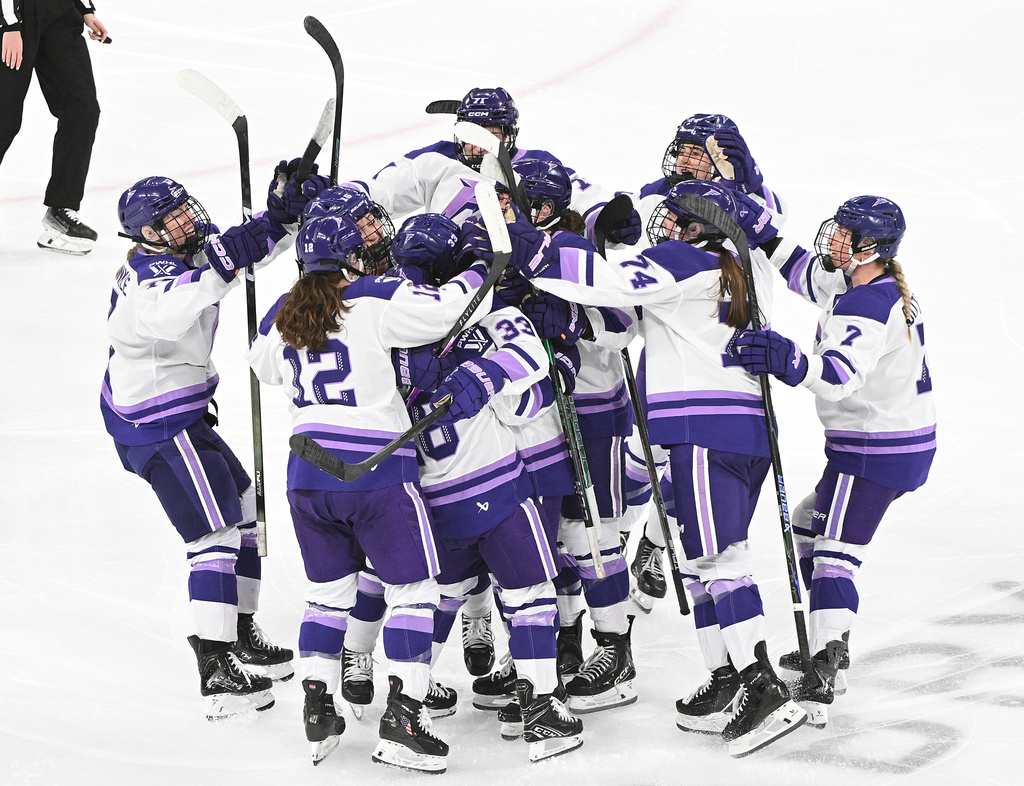 Minnesota Frost's Jincy Roese (33) is mobbed by teammates after scoring during the overtime of an PWHL playoff hockey game against the Montreal Victoire in Laval, Que., Saturday, May 2, 2026. (Graham Hughes/The Canadian Press via AP)