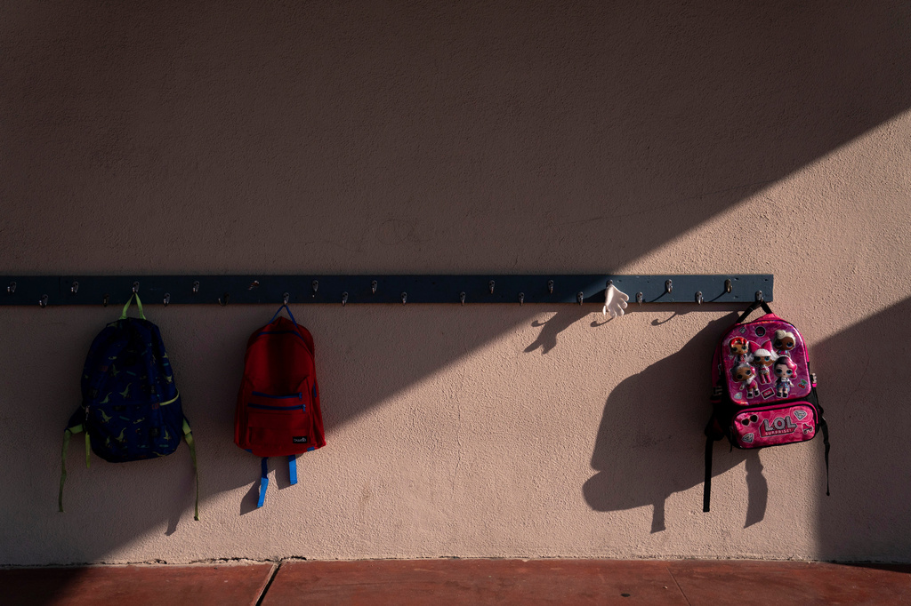 FILE - School backpacks hang on a rack at an elementary school in Orange, Calif., March 18, 2021. (AP Photo/Jae C. Hong, File)