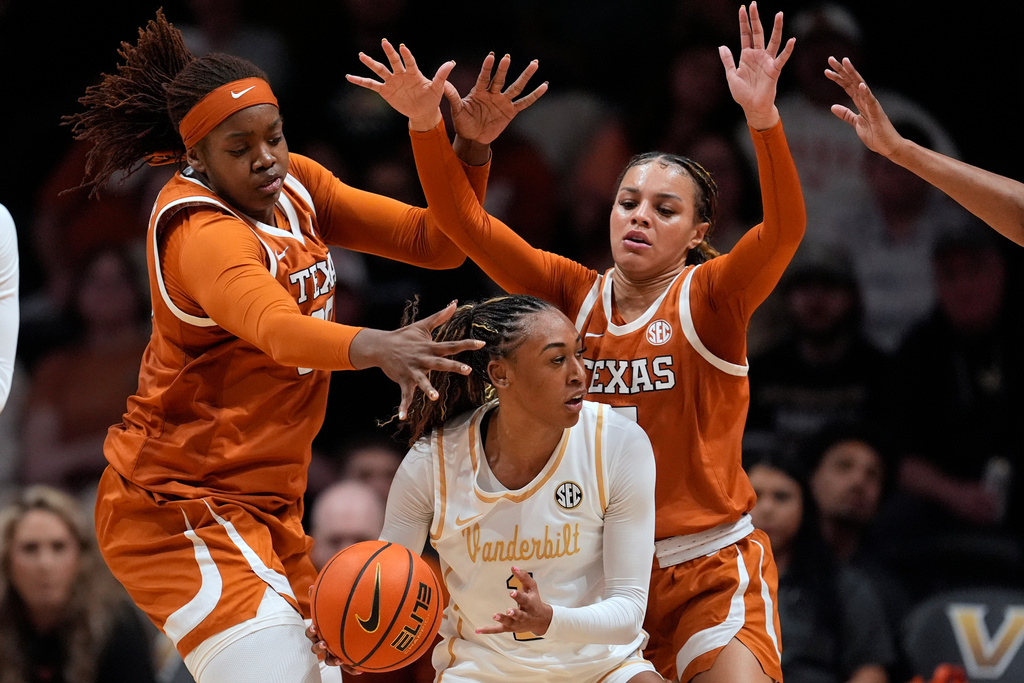 Texas center Kyla Oldacre, left, and Texas guard Jordan Lee, right, defend Vanderbilt guard Mikayla Blakes, center, during the first half of an NCAA college basketball game Thursday, Feb. 12, 2026, in Nashville, Tenn. (AP Photo/George Walker IV)