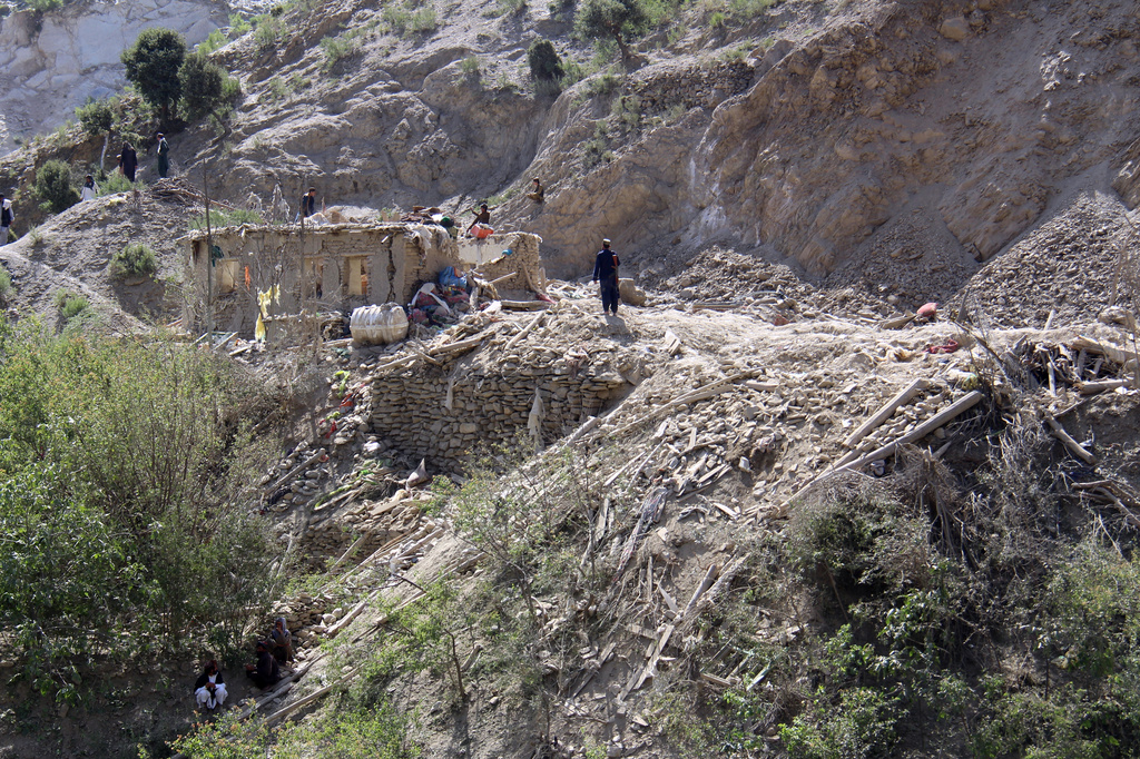 Residents walk among the ruins of mud-brick homes after airstrikes that Taliban officials said were carried out by Pakistan and killed civilians, including children, in Mana, a village in Afghanistan's Khost province, Wednesday, June 10, 2026. (AP Photo/Saifullah Zahir)