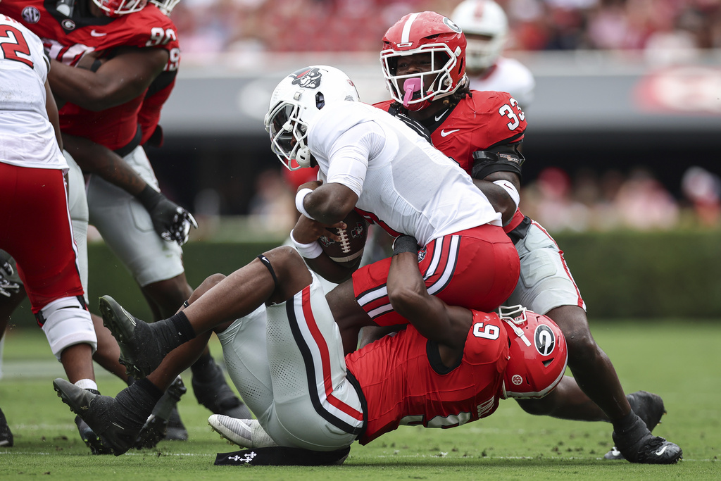 Austin Peay quarterback Chris Parson, center, gets sacked by Georgia linebacker Chris Cole (9) during the first half of an NCAA college football game, Saturday, Sept. 6, 2025, in Athens, Ga. (AP Photo/Colin Hubbard)