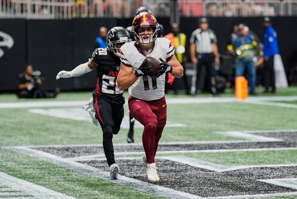 Washington Commanders wide receiver Luke McCaffrey (11) scores a touchdown past Atlanta Falcons cornerback Dee Alford (20) during the first half of an NFL football game, Sunday, Sept. 28, 2025, in Atlanta. (AP Photo/Mike Stewart)