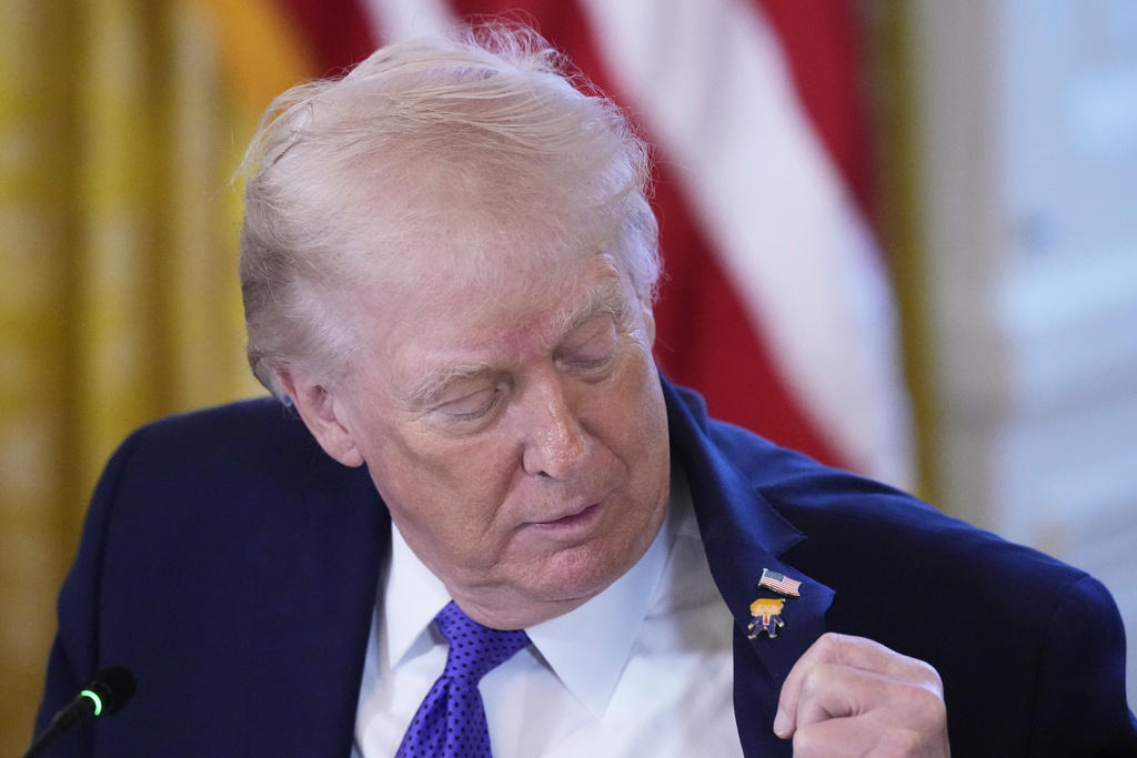 President Donald Trump wears a gift, which he calls a "Happy Trump" pin, during a meeting with oil executives in the East Room of the White House, Friday, Jan. 9, 2026, in Washington. (AP Photo/Alex Brandon)