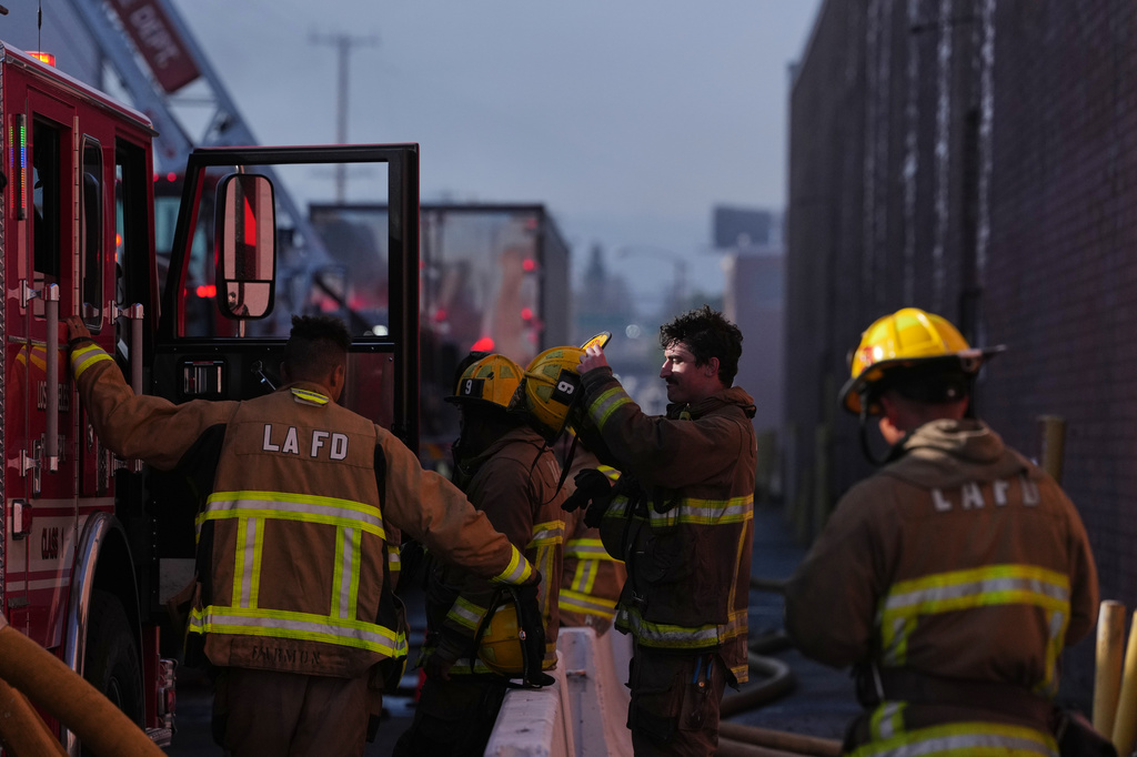 Fire crews stage outside a warehouse in the Boyle Heights section of Los Angeles on Wednesday, June 17, 2026. (AP Photo/Jae C. Hong)