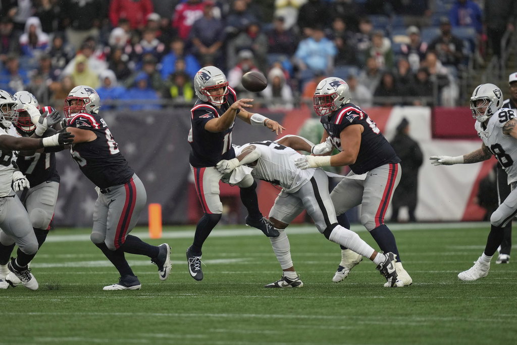New England Patriots quarterback Drake Maye (10) throws while hit by Las Vegas Raiders defensive end Malcolm Koonce (51) during the second half of an NFL football game, Sunday, Sept. 7, 2025, in Foxborough, Mass. (AP Photo/Charles Krupa)