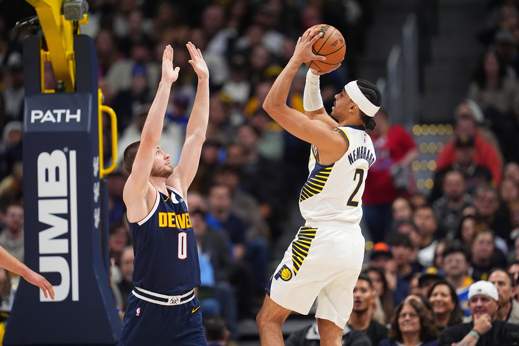 Indiana Pacers guard/forward Andrew Nembhard, right, goes up for a basket over Denver Nuggets guard Christian Braun in the first half of an NBA basketball game Saturday, Nov. 8, 2025, in Denver. (AP Photo/David Zalubowski)