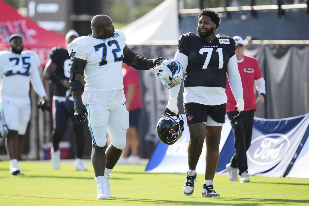 Carolina Panthers offensive tackle Taylor Moton (72) greets Houston Texans offensive tackle Tytus Howard (71) during a joint NFL football practice Thursday, Aug. 14, 2025, in Houston. (AP Photo/Ashley Landis)