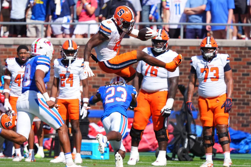 Syracuse running back Yasin Willis (6) leaps over SMU safety Isaiah Nwokobia (23) during the first half of an NCAA college football game Saturday, Oct. 4, 2025, in Dallas. (AP Photo/LM Otero)