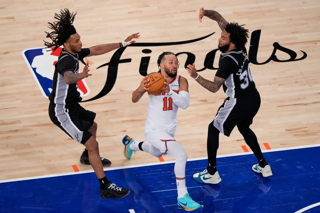 New York Knicks guard Jalen Brunson (11) drives past San Antonio Spurs defenders during the second half of Game 3 of the NBA Finals basketball series, Monday, June 8, 2026, in New York. (AP Photo/Yuki Iwamura)
