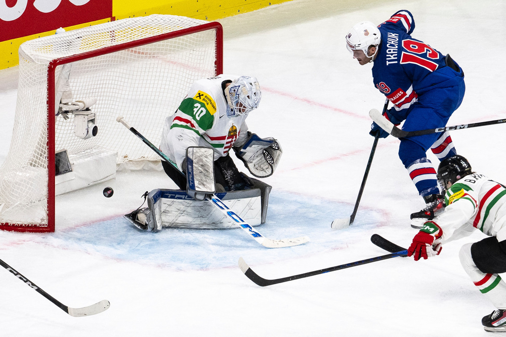 Matthew Tkachuk of the U.S., right, scores against Hungary's goaltender Adam Vay during the 2026 IIHF Men's Ice Hockey World Championship preliminary round group A game between United States and Hungary, in Zurich, Switzerland, Monday, May 25, 2026. (Andreas Becker/Keystone via AP)