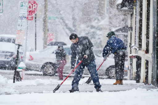FILE - People clear a sidewalk during a winter snowstorm in Philadelphia, Feb. 13, 2024. (AP Photo/Matt Rourke, File) FILE - People clear a sidewalk during a winter snowstorm in Philadelphia, Feb. 13, 2024. (AP Photo/Matt Rourke, File)