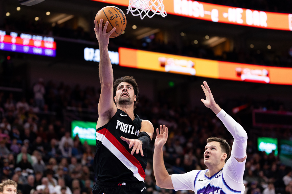 Portland Trail Blazers forward Deni Avdija, left, shoots over Utah Jazz center Walker Kessler, right, during the first half of an NBA basketball game, Wednesday, Oct. 29, 2025, in Salt Lake City. (AP Photo/Anna Fuder)