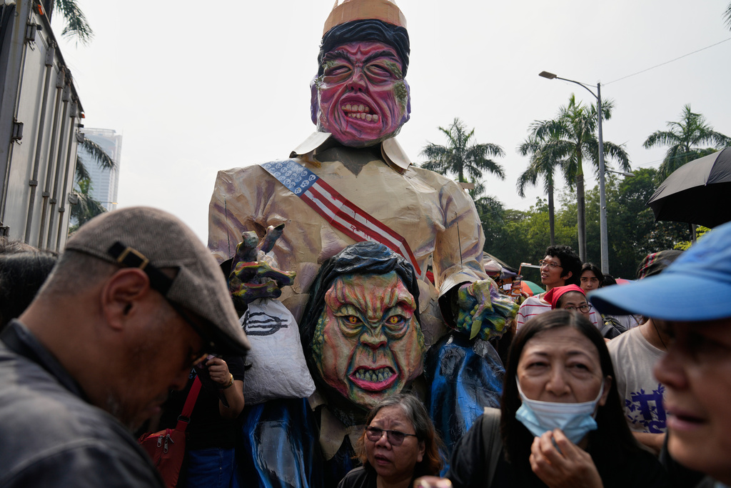 Protesters take part in an anti-corruption protest in front of the effigies of Philippine President Ferdinand Marcos Jr., and Vice President Sara Duterte, in Manila, Philippines on Sunday Nov. 30, 2025. (AP Photo/Aaron Favila)