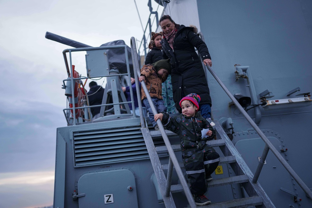 A mother with her children walk on stairs of a naval vessel during a public day in Nuuk, Greenland, Saturday, Jan. 24, 2026. (AP Photo/Evgeniy Maloletka)