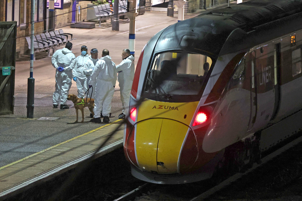 Forensic investigators on the platform by a train at Huntingdon station after a mass stabbing on a London-bound train in eastern England, in Cambridgeshire, England, Saturday, Nov. 1, 2025. (Chris Radburn/PA via AP)