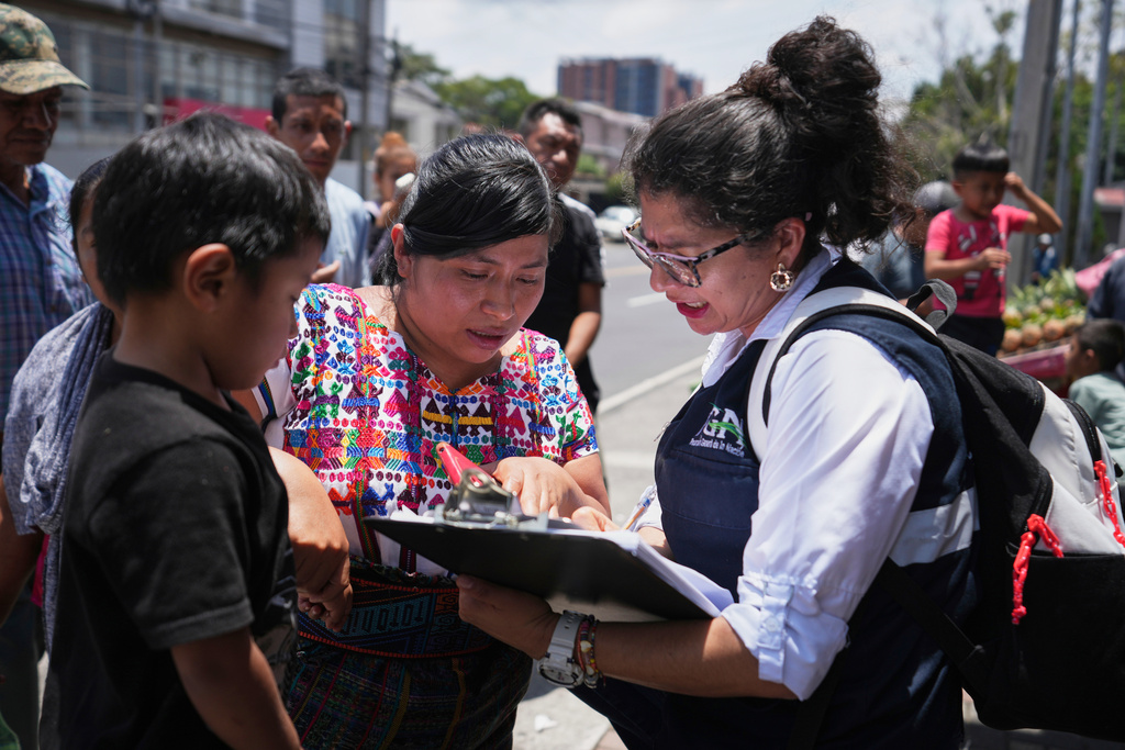 FILE - A relative of an unaccompanied minor deported from the United States reviews the list of those deported outside La Aurora International Airport, in Guatemala City, Aug. 31, 2025. (AP Photo/Moises Castillo, File)