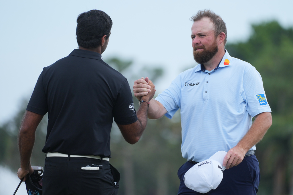 Shane Lowry of Ireland shakes hands with Aaron Rai of England, at the end of the third round of the Cognizant Classic golf tournament, Saturday, Feb. 28, 2026, in Palm Beach Gardens, Fla. (AP Photo/Marta Lavandier)