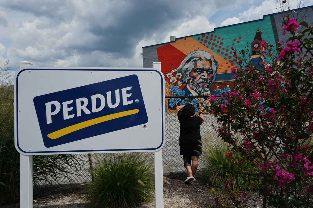 A Honduran woman poses for a portrait outside the Perdue Farms poultry plant, where she worked for more than two decades before losing her job the previous year after her TPS expired in Salisbury, Md., Saturday, Aug. 1, 2026. (AP Photo/Luis Andres Henao)