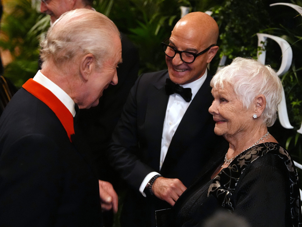 Britain's King Charles III speaks to Stanley Tucci and Judi Dench in the Grand Reception Room after they attended the premiere of Prime Video's Finding Harmony: A King's Vision, at Windsor Castle in Berkshire, England, Wednesday, Jan. 28, 2026. (Jonathan Brady/Pool Photo via AP)