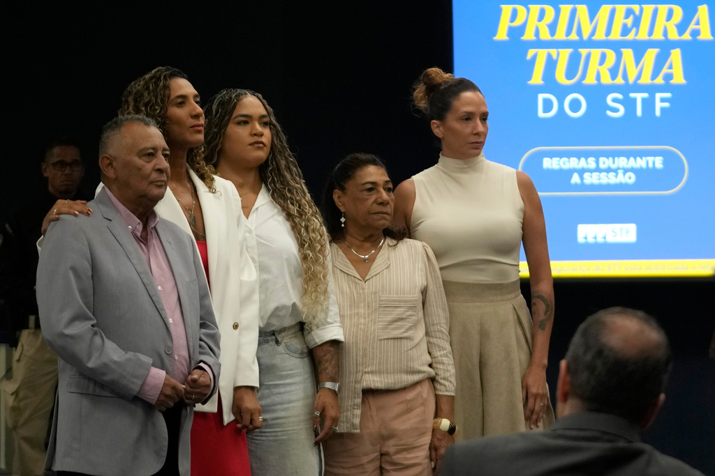 Antonio Francisco, left, the father of the councilwoman Marielle Franco, pose for photos with his daughter Anielle Franco, who is Minister of Racial Equality, second from left, and his granddaughter Luyara Franco, third from the left, his wife Marinete Silva, second from right, and Monica Benicio, the widow of Marielle Franco, before the start of the second day of the trial of those accused of ordering the murder of Marielle Franco, at the Supreme Court in Brasilia, Brazil, Wednesday, Feb. 25, 2026. (AP Photo/Eraldo Peres)