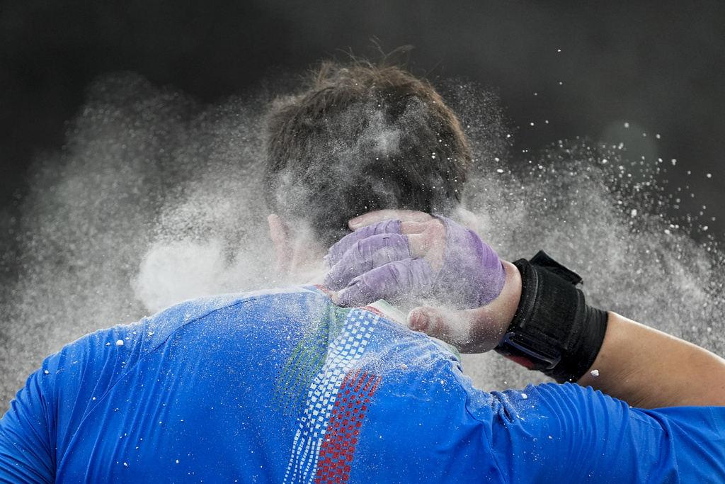 Italy's Leonardo Fabbri chalks his neck as he competes in the men's shot put final at the World Athletics Championships in Tokyo, Saturday, Sept. 13, 2025. (AP Photo/Ashley Landis)