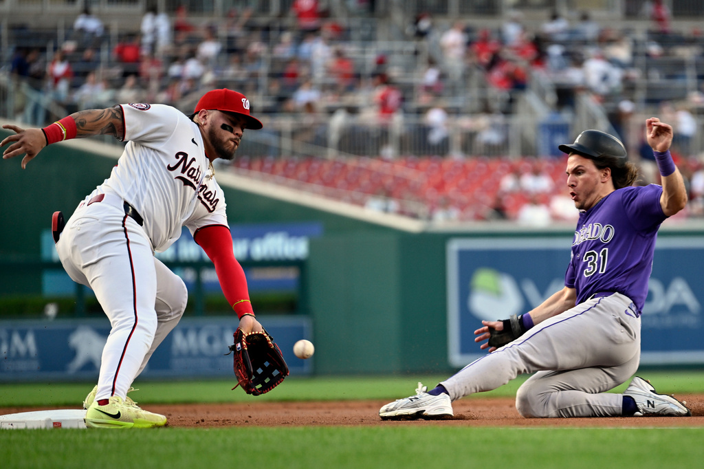 Colorado Rockies' Jake McCarthy beats the throw to Washington Nationals third baseman Andrés Chaparro for a steal during the first inning of a baseball game, Wednesday, Aug. 26, 2026, in Washington. (AP Photo/John McDonnell)