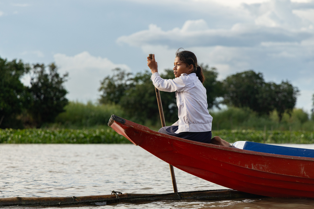 A student from a floating village steers a school boat on Tonle Sap Lake, Cambodia, Monday, June 29, 2026. (AP Photo/Anton L. Delgado)