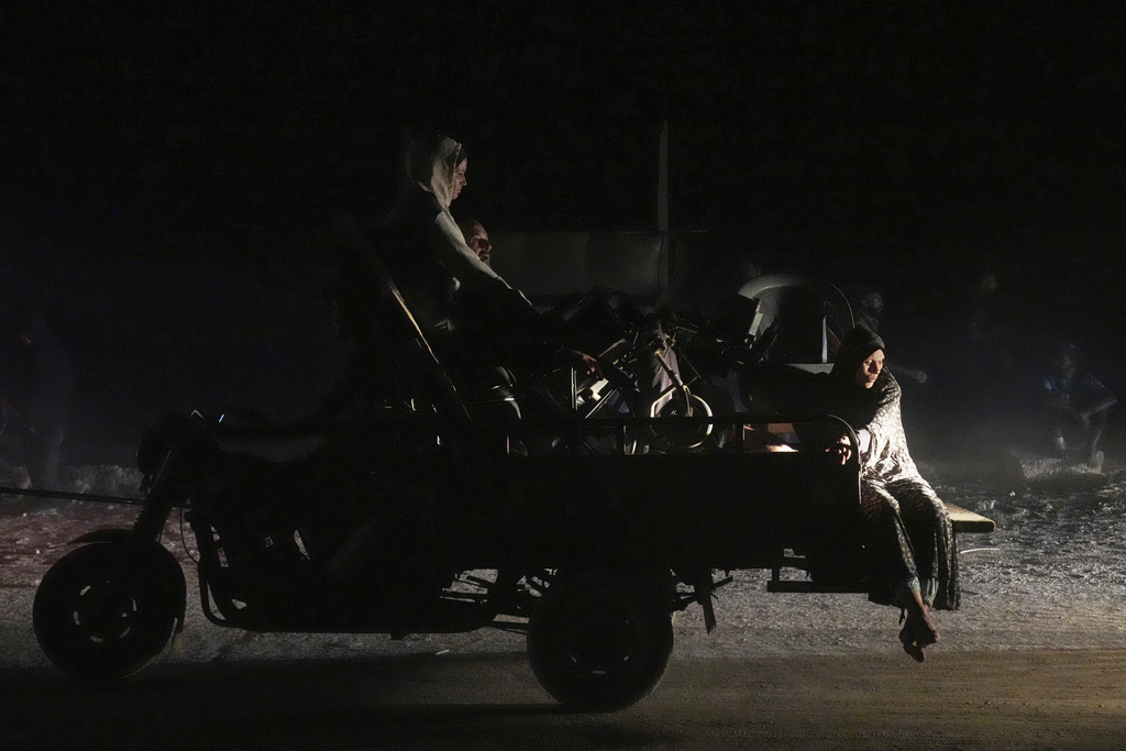 Displaced Palestinians flee Gaza City carrying their belongings along the coastal road toward southern Gaza, Thursday, Sept. 18, 2025. (AP Photo/Abdel Kareem Hana)