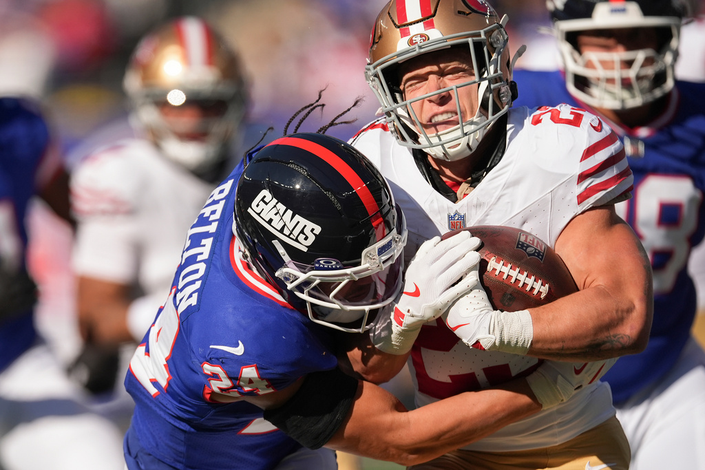 San Francisco 49ers running back Christian McCaffrey (23) is hit by New York Giants safety Dane Belton (24) during the first quarter of an NFL football game, Sunday, Nov. 2, 2025, in East Rutherford, N.J. (AP Photo/Seth Wenig)