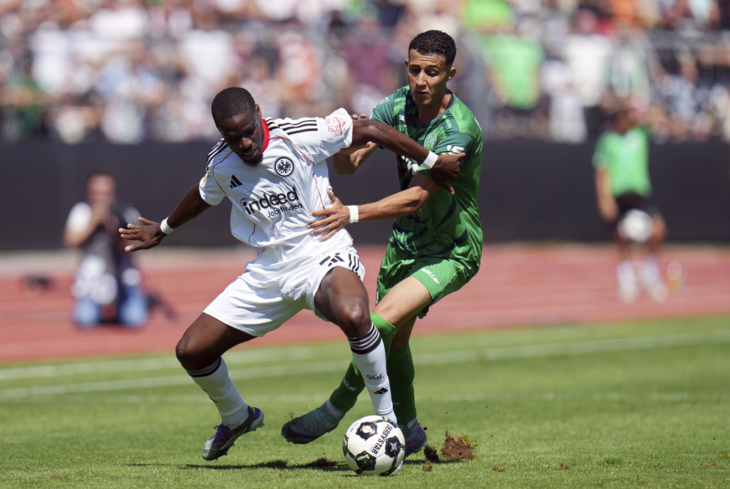Frankfurt's Niels Nkounkou, left, and Enger's Ed-Daoudi Ayman, right, challenge for the ball during the German soccer cup first round match between FV Engers and Eintracht Frankfurt in Koblenz, Germany, Sunday Aug. 17, 2025. (Thomas Frey/dpa via AP)