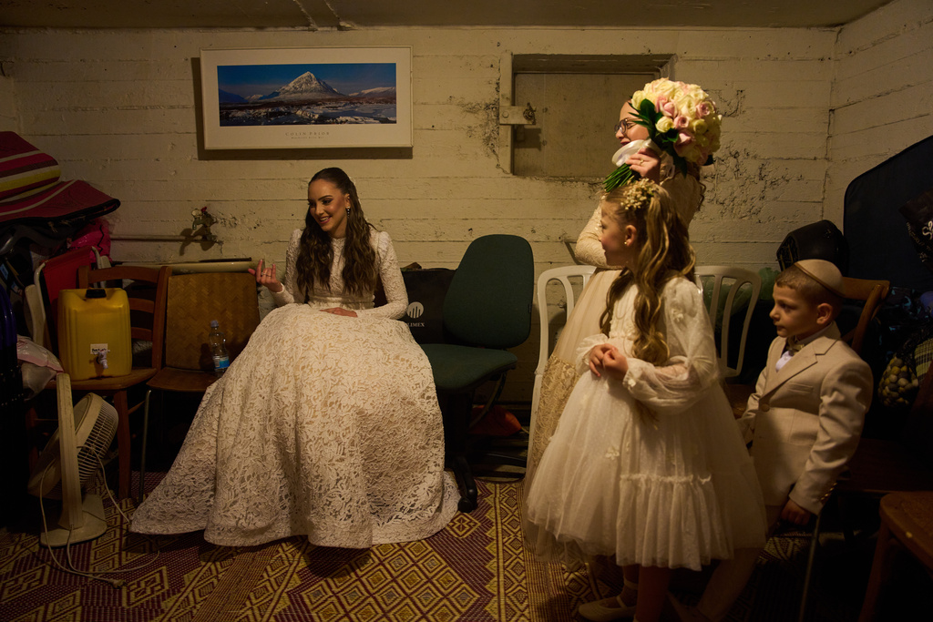 A bride and her family in the midst of a wedding photo session take cover in a bomb shelter after an alert from Israel's Home Front Command warned of missiles fired from Iran toward central Israel, in Ramat Gan, Israel, Thursday, March 19, 2026. (AP Photo/Oded Balilty)
