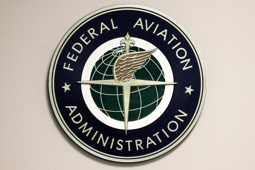 FILE - A Federal Aviation Administration sign hangs in the tower at John F. Kennedy International Airport in New York, March 16, 2017. (AP Photo/Seth Wenig, File)