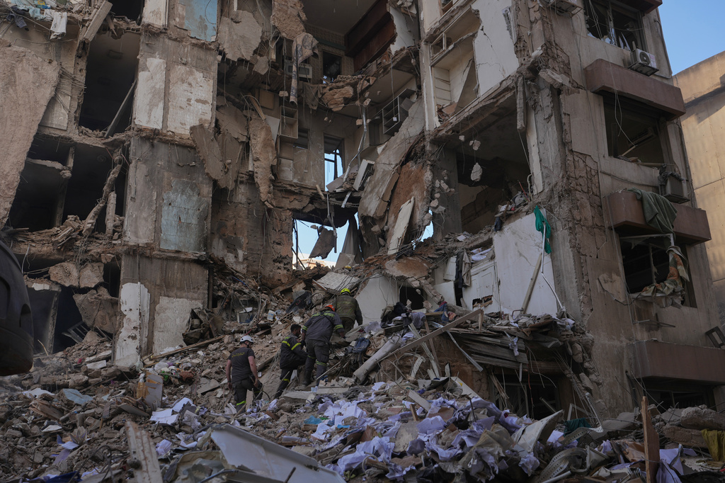 Lebanese civil defense workers search for victims in the rubble of a building destroyed in an Israeli airstrike a day earlier in central Beirut, Lebanon, Thursday, April 9, 2026. (AP Photo/Hassan Ammar)
