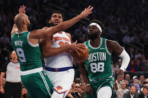 New York Knicks' Karl-Anthony Towns, center, drives to the basket while Boston Celtics' Derrick White (9) and Neemias Queta (88) defend during the first half of an NBA basketball game, Friday, Oct. 24, 2025, in New York. (AP Photo/Heather Khalifa) New York Knicks' Karl-Anthony Towns, center, drives to the basket while Boston Celtics' Derrick White (9) and Neemias Queta (88) defend during the first half of an NBA basketball game, Friday, Oct. 24, 2025, in New York. (AP Photo/Heather Khalifa)